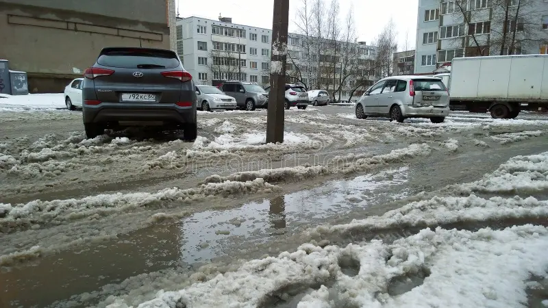 грязный-снег-таял-с-водой-на-дороге-зимняя-погода-в-городе-проблема-для-206416104